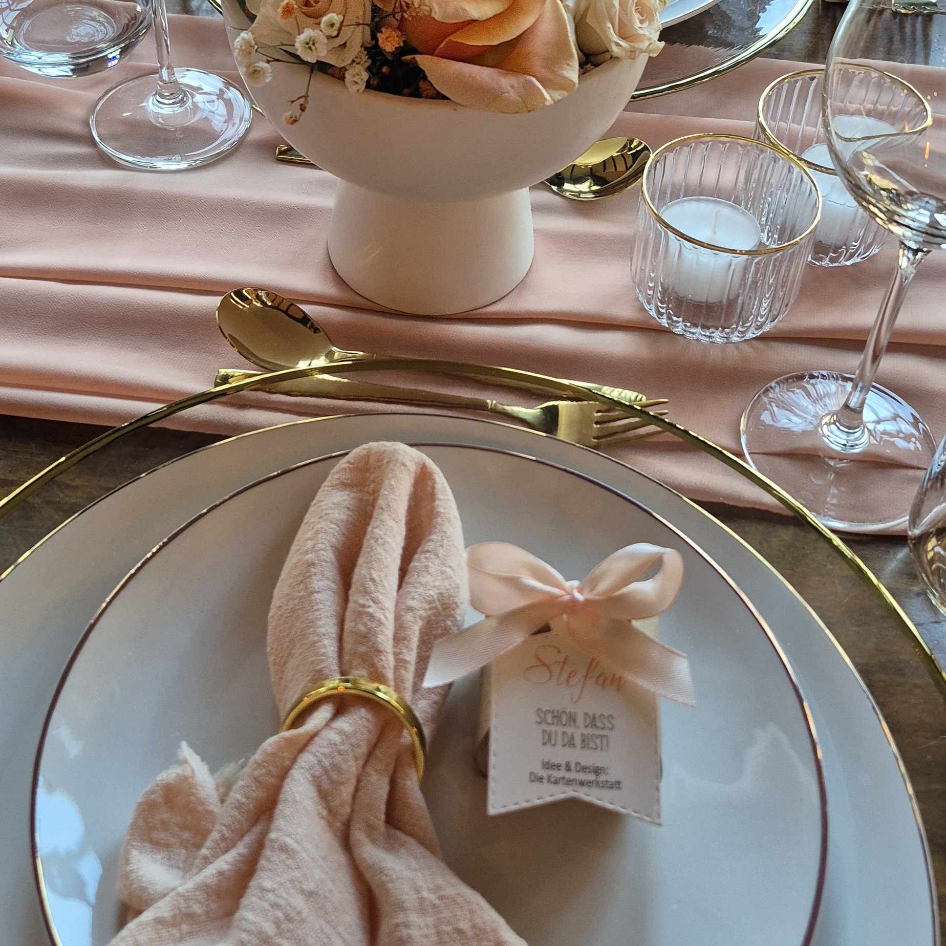 Gastgeschenk-Hochzeit-bauchige-Box Gastgeschenk zur Hochzeit bauchig auf Teller neben Serviette dekoriert mit Schleife in apricot und Namensanhänger