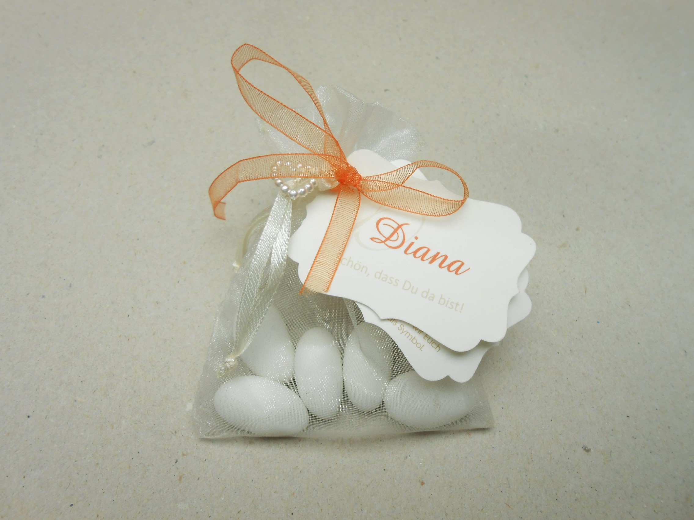 Hochzeitsmandeln als Gastgeschenk im Organzasäckchen Organzasäckchen mit Hochzeitsmandeln, Perlenherz und Anhänger als Hochzeitsgastgeschenk